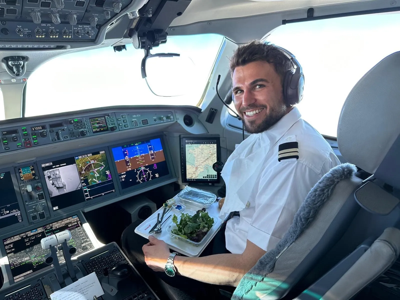 Lukas sitting in an airplane cockpit wearing a pilot headset