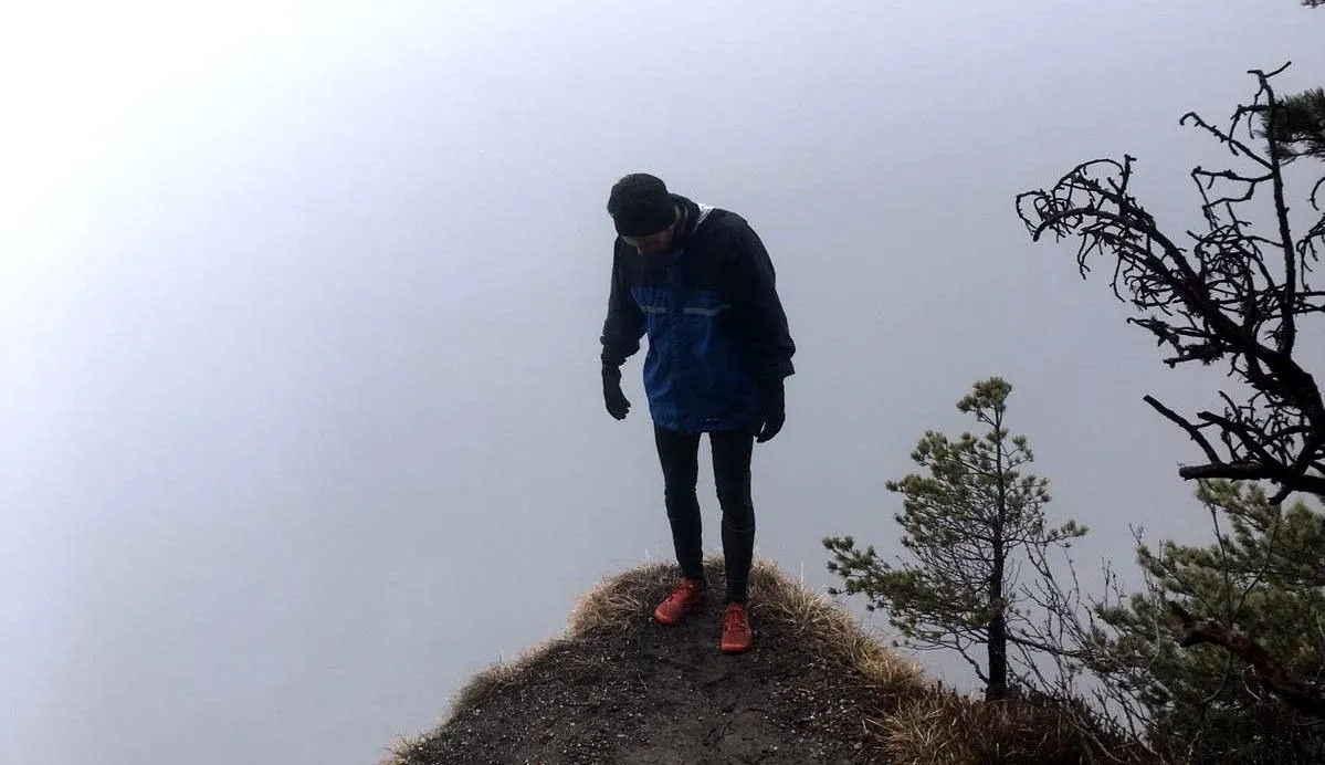 Hiker standing on a misty mountain ridge