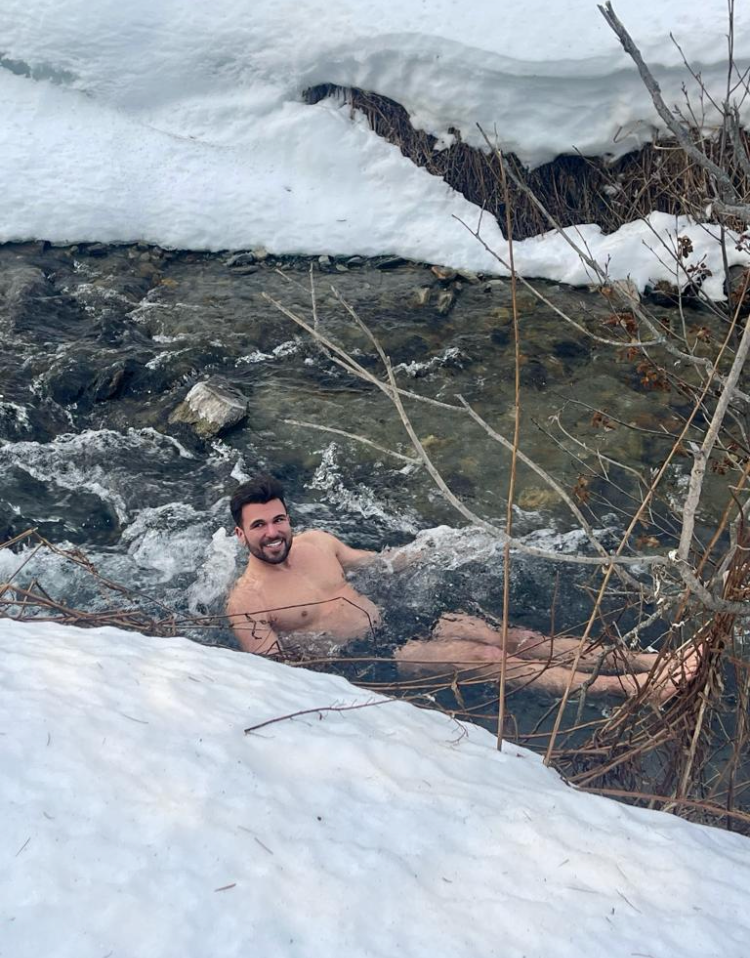 taking a bath in a river with snow on the shore in Austria and laughing